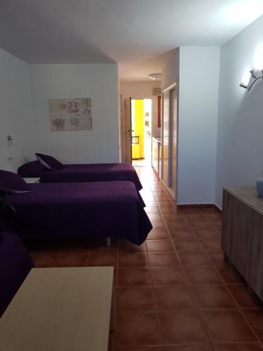 una habitación de hotel con dos camas y una mesa en Torres Los Cristianos, en Arona