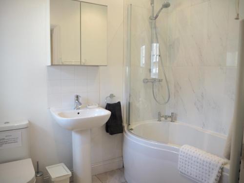 a bathroom with a sink and a tub and a shower at Old Stables in Pulborough