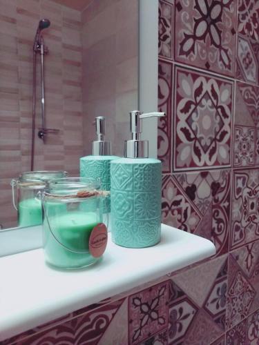 a bathroom with two green towels on a shelf at АpartmentAnna in Odesa