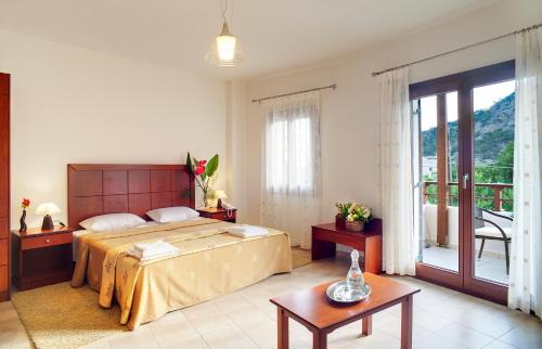 a bedroom with a large bed and a balcony at Syia Hotel in Sougia