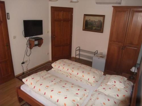 a bedroom with a bed and a flat screen tv at Sóvirág Vendégház in Hortobágy