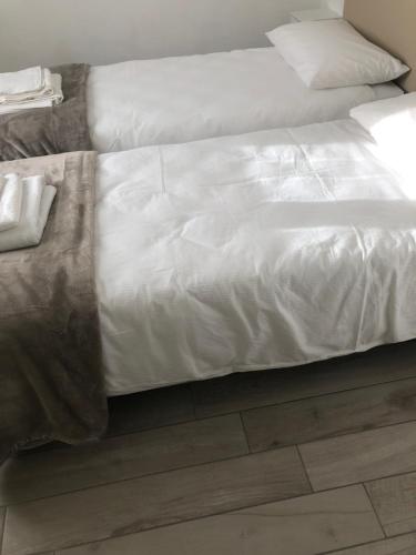 białe łóżko z drewnianą podłogą w obiekcie VILLA ZAIRA w mieście Il Cristo