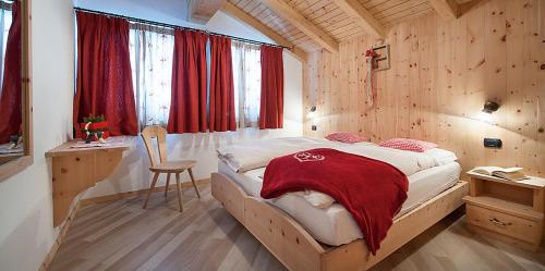 a bedroom with a bed with a red blanket on it at Chalet in Via Dali Mina in Livigno