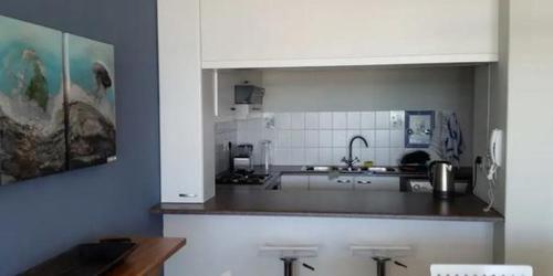 a kitchen with a sink and a counter top at Dolphin Beach Apartment in Table View