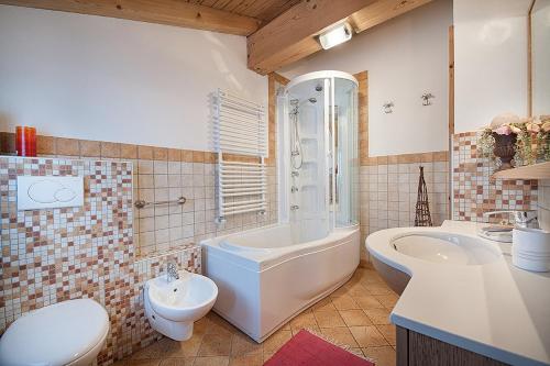a bathroom with a tub and a toilet and a sink at Chalet in Via Dali Mina in Livigno