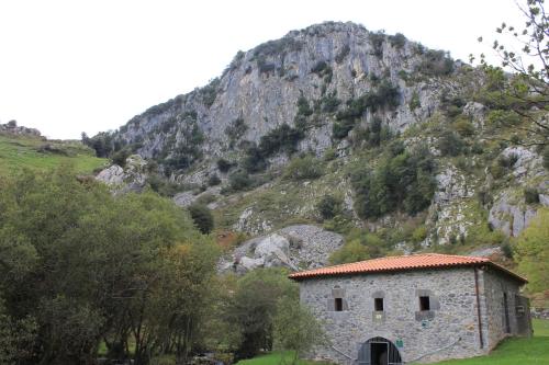 a stone building in front of a mountain at Balcón de la Len in Quintana de Soba