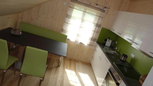uma cozinha com balcões verdes e brancos e uma mesa em Erwins Ferien-Paradies em Hörbranz