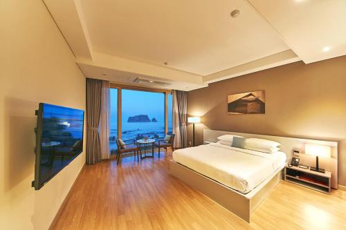 a bedroom with a bed and a view of the ocean at The Grand Sumorum in Seogwipo