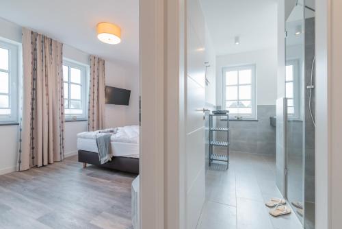 a bedroom with a bed and a walk in shower at Haus Strandperle in Börgerende-Rethwisch