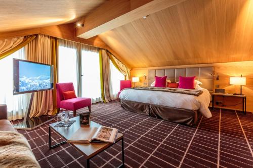 pokój hotelowy z łóżkiem i telewizorem w obiekcie Hotel Le Savoy w Méribel