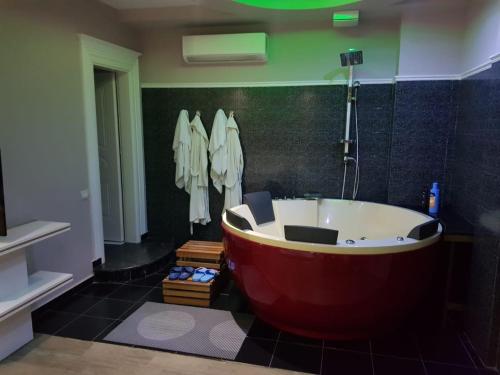 Lushnjë的住宿－Hotel Kresko，浴室铺有黑色瓷砖,配有红色浴缸。