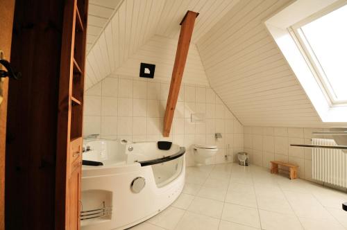 een witte badkamer met een bad en een toilet bij Ferienhaus Hinterzarten in Hinterzarten