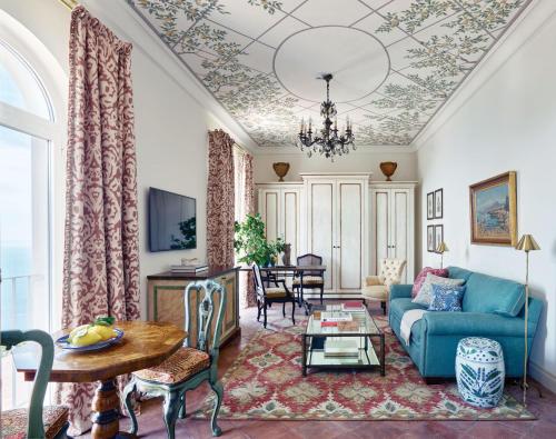 a living room with a blue couch and a table at Villa Margherita by Belmond in Ravello