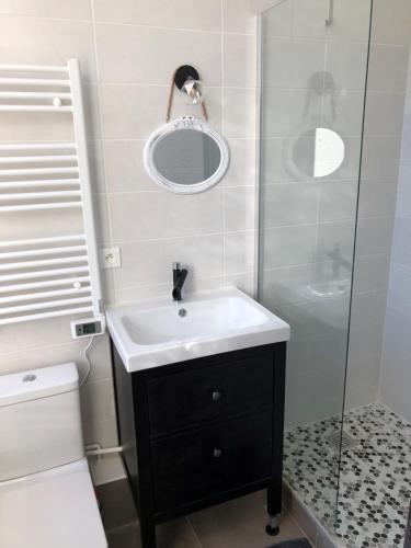 a bathroom with a sink and a glass shower at chateau fourclins in Merville