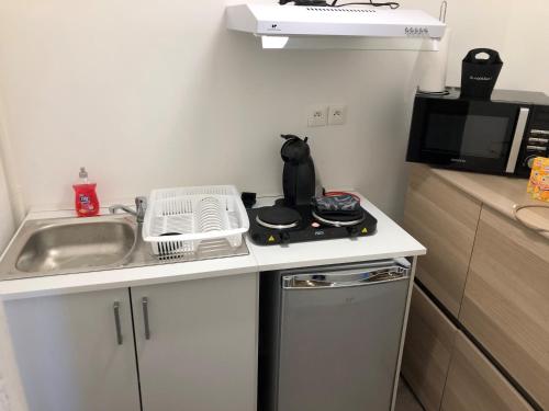 a small kitchen with a sink and a stove at chateau fourclins in Merville