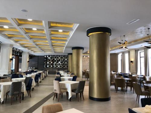a dining room with tables and chairs and columns at Jermuk Hotel and SPA in Jermuk