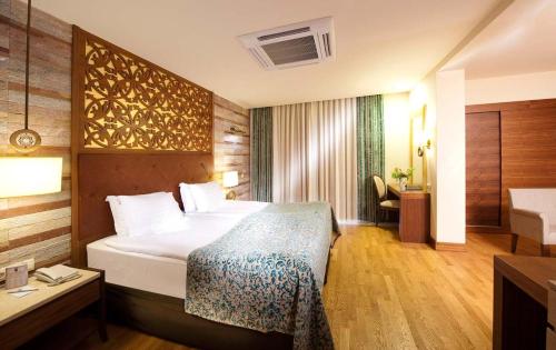 a hotel room with a bed and a desk at Melas Lara Hotel in Lara