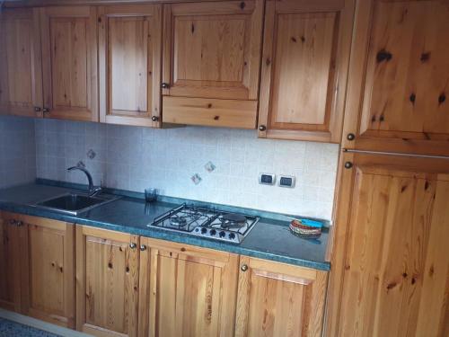 una cucina con armadi in legno e piano cottura. di Il Dehors a Champdepraz
