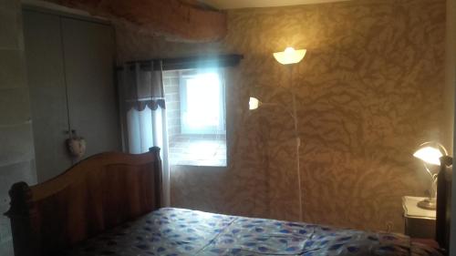 Schlafzimmer mit einem Bett und einem Fenster in der Unterkunft Logis de Bois Roche (2) in Saint-Bonnet-sur-Gironde