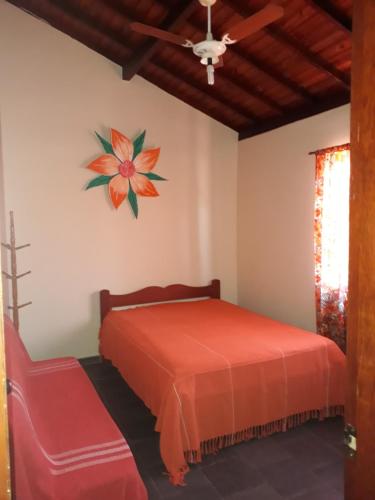 a bedroom with a bed and a flower on the wall at Casa Completa na Praia in Saquarema
