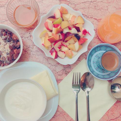 a table with plates of food and a bowl of fruit at Riad Idrissy in Fès