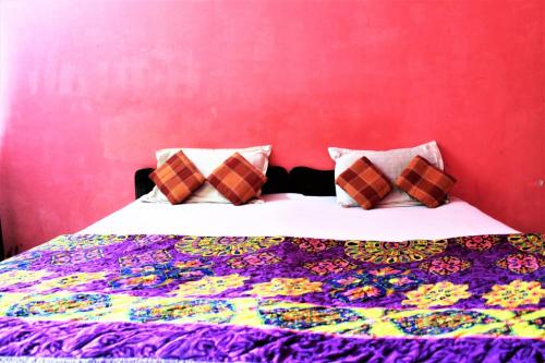 a bedroom with a bed with a colorful quilt at Private rooms near Chapora fort in Vagator