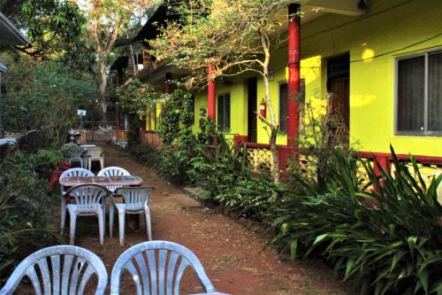 a group of tables and chairs in front of a yellow building at Private rooms near Chapora fort in Vagator