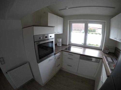 a kitchen with white cabinets and a stove top oven at Ferienwohnung am Schloss in Königstein in Kürmreuth