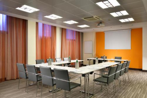 a conference room with a long table and chairs at UNA Hotels Mediterraneo Milano in Milan