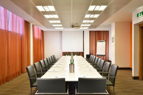 a conference room with a long table and chairs at UNA Hotels Mediterraneo Milano in Milan