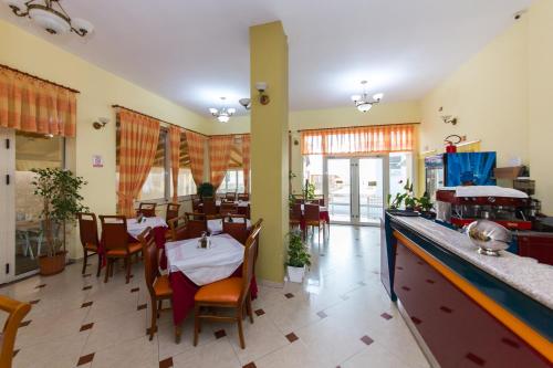 a dining room with tables and chairs in a restaurant at Hotel Vila Misiri in Durrës