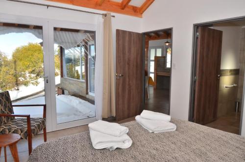 a room with a bed with two towels on it at Cabañas Agua Clara in Villa Pehuenia