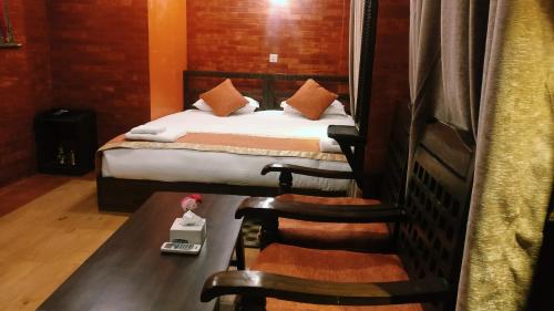 a small room with a bed and a chair in it at Temple House in Kathmandu