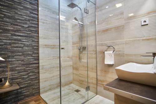 uma casa de banho com uma cabina de duche em vidro e um lavatório. em K51 Apartman | Budapest em Budapeste