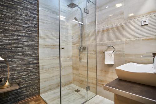 a bathroom with a glass shower and a sink at K51 Apartman | Budapest in Budapest