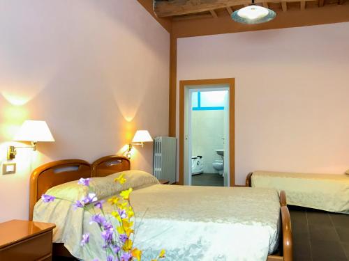 a hotel room with two beds and a bathroom at Hotel Antico Borgo in Riolo Terme