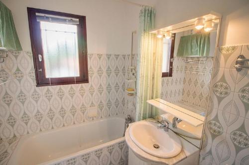 a bathroom with a sink and a toilet and a tub at Les Genêts in Mimizan-Plage