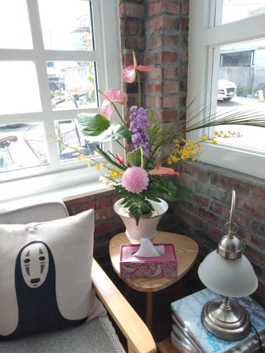a living room with a vase of flowers on a table at 小時公館城西 in Yuli