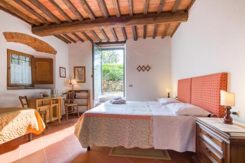 a bedroom with a bed and a desk and a window at Ancora del Chianti in Greve in Chianti