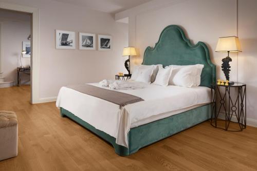 a bedroom with a large bed with a green headboard at Villa Azzurra in Vabriga