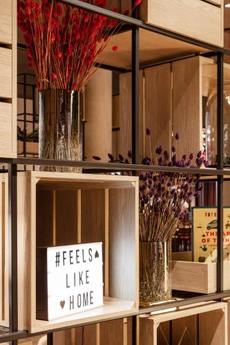 a shelf with vases with flowers and a sign at IntercityHotel Frankfurt Hauptbahnhof Süd in Frankfurt/Main