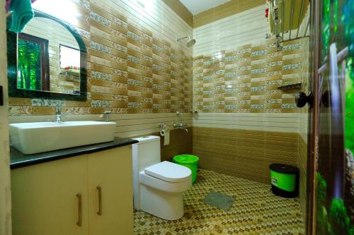 a bathroom with a sink and a toilet in it at Marari Lotus Beach Villa in Mararikulam