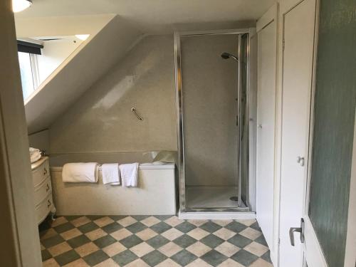 a bathroom with a shower with towels and a sink at Creebridge House Hotel in Newton Stewart