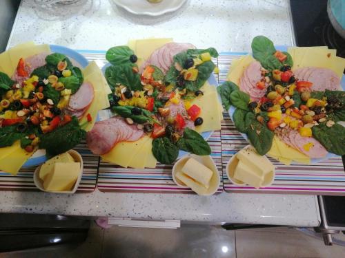 ein Tablett mit Käse, Fleisch und Gemüse auf dem Tisch in der Unterkunft DobraNoc in Łódź