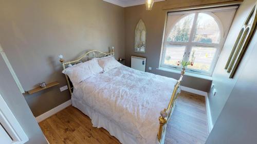 a bedroom with a bed and a window at Little Bury Barn in Bury Saint Edmunds