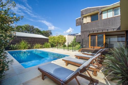 une arrière-cour avec une piscine et une maison dans l'établissement Byron Bay Accom Byron Beausoleil - Belongil Beach, à Byron Bay