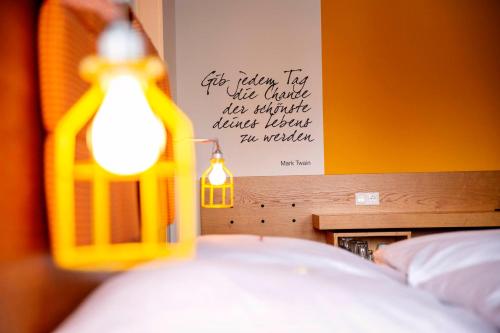 a bedroom with a bed with a sign on the wall at Hotel Gut Schwaige in Ebenhausen