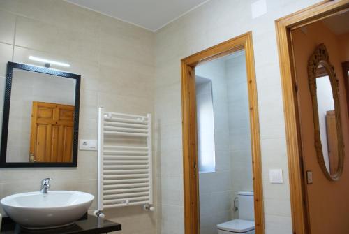 uma casa de banho com um lavatório, um WC e um espelho. em Casa Crescente em Boca de Huérgano