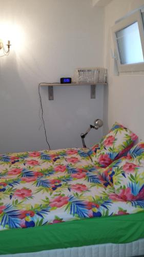 - un lit avec une couette colorée dans une chambre dans l'établissement WIFI Appartement Panoramisch Zeezicht max 4 personen in Narbonne Plage, à Narbonne-Plage