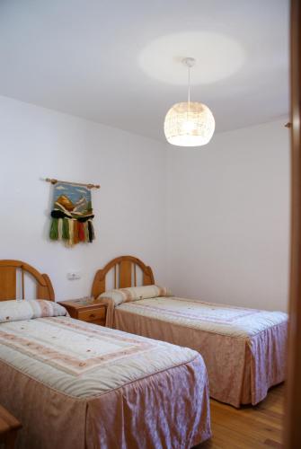 a room with two beds and a chandelier at Casa Crescente in Boca de Huérgano